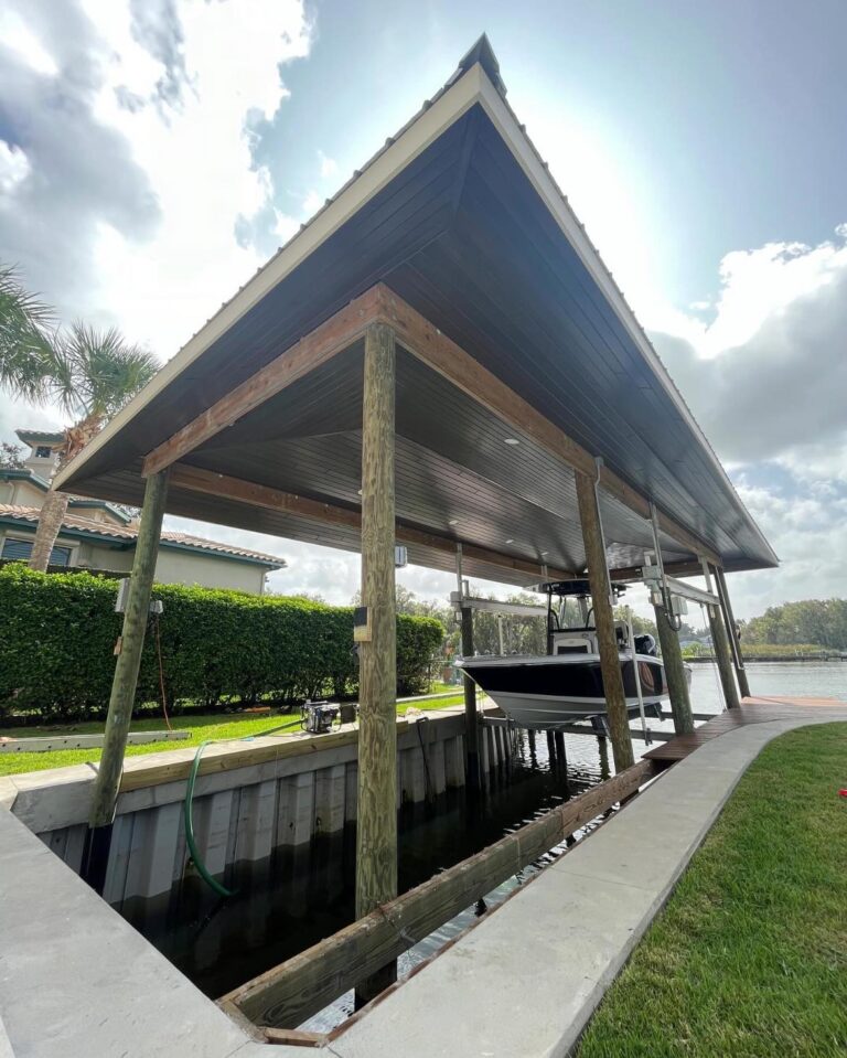 Wooden boat dock with a pitched metal roof, a motorboat in the slip, and a canal in the background.