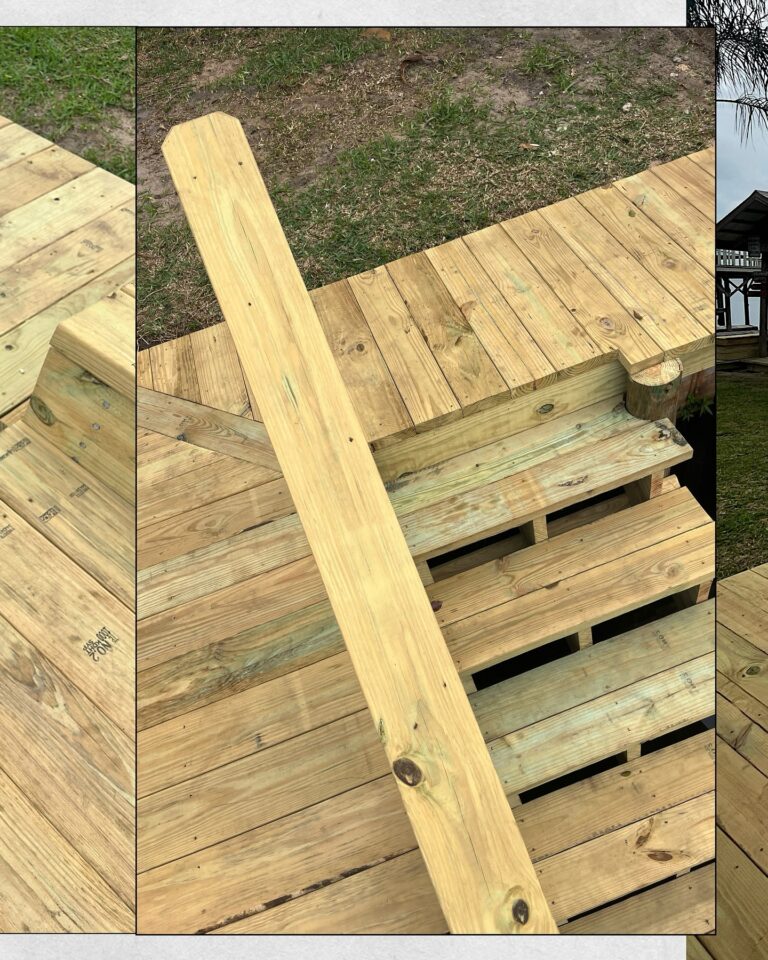 Unfinished wooden deck with many planks laid out and a long diagonal board resting on top, outdoors on bare ground.