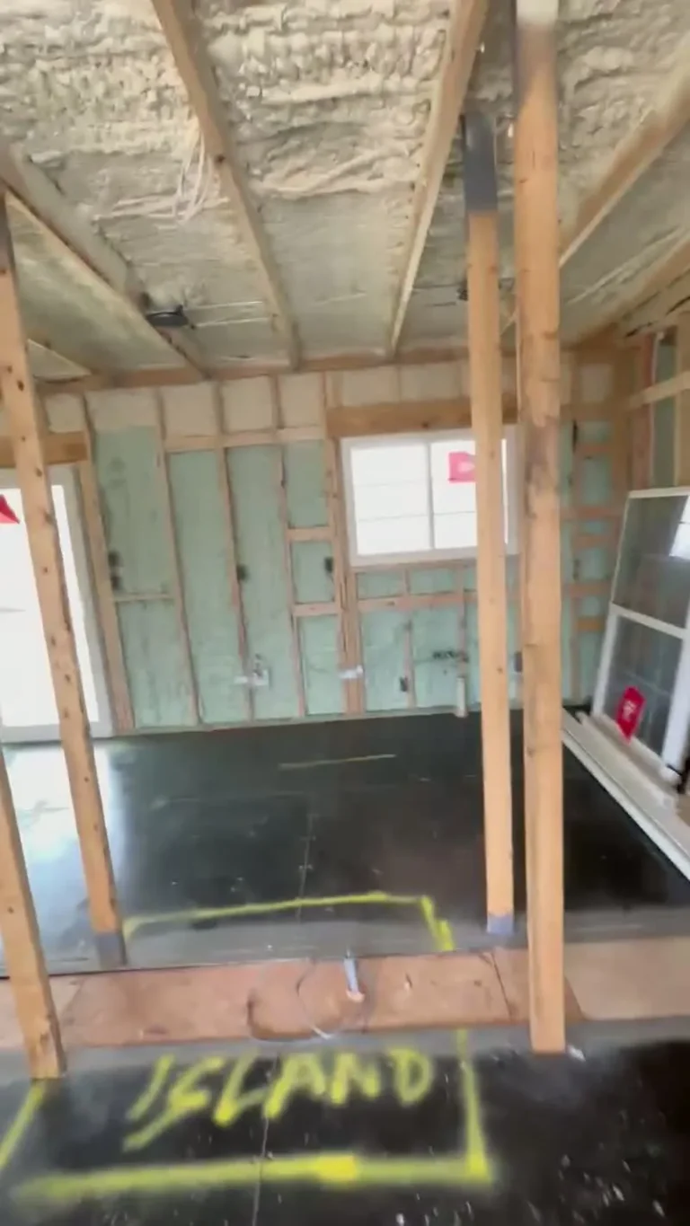 Closed-cell spray foam insulation inside a JSC container home build in Florida with the kitchen island layout marked on the floor